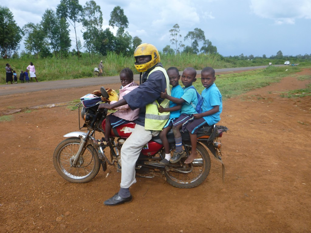 Children being taken to and from school on a Beda Beda, a motorbike taxi
